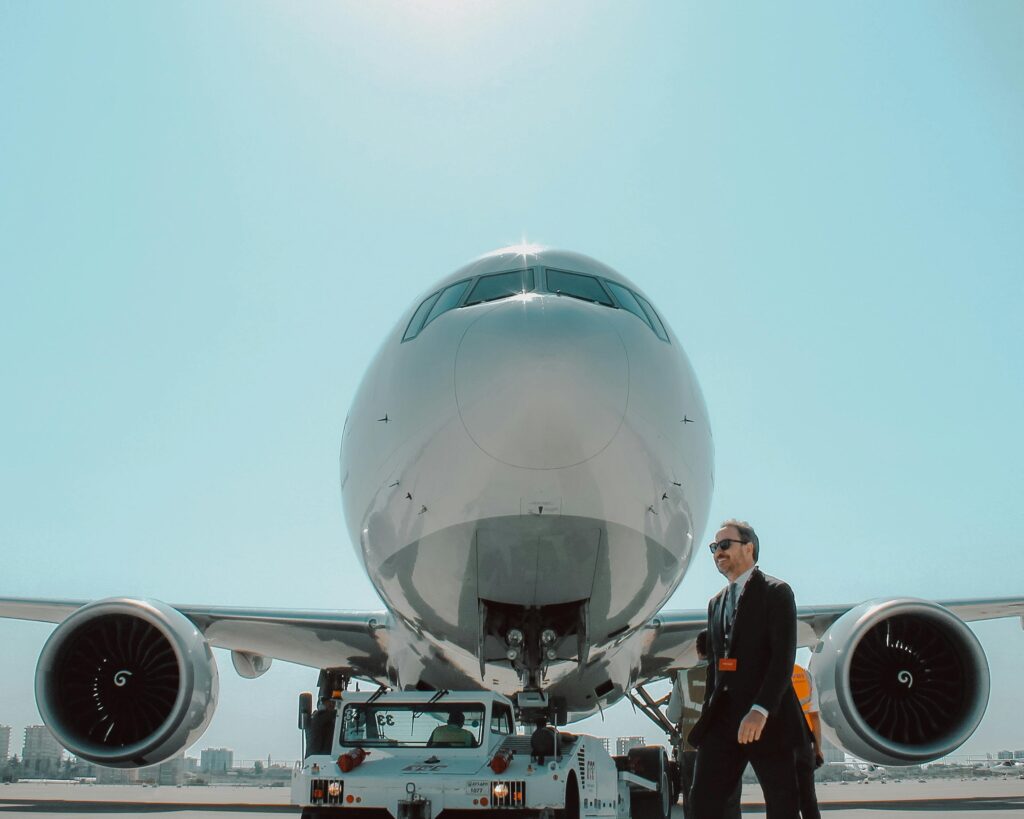 A businessman walks near a large jet airliner parked on the tarmac under a clear sky in Antalya.